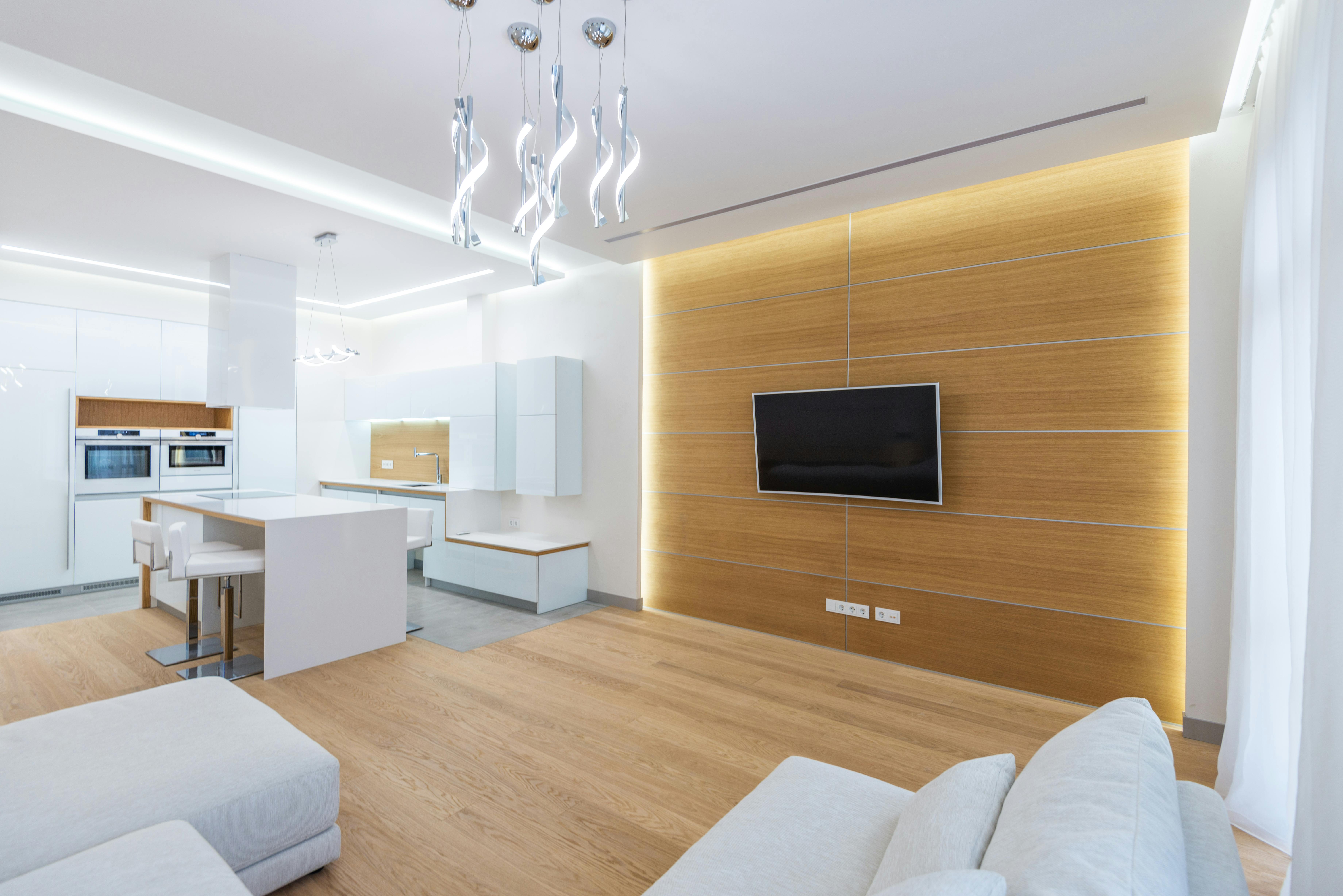 pexels-photo-7214467-7214467 Elegant open-plan living room and kitchen with modern design and lighting.